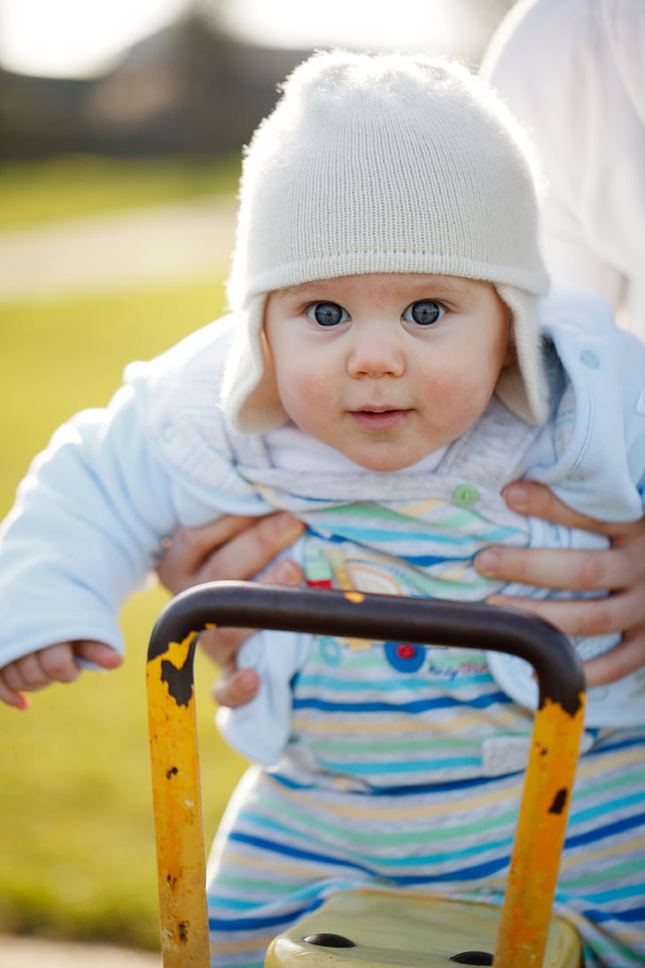 shallow focus photography of person carrying baby