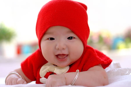 baby wearing red top and knit cap