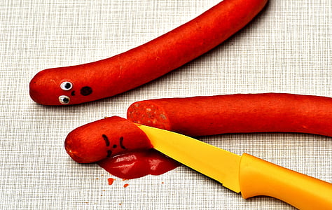 orange knife beside hotdog