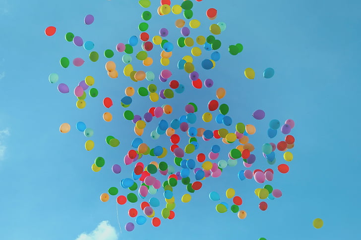 assorted-colored inflated latex balloons floating under blue sky