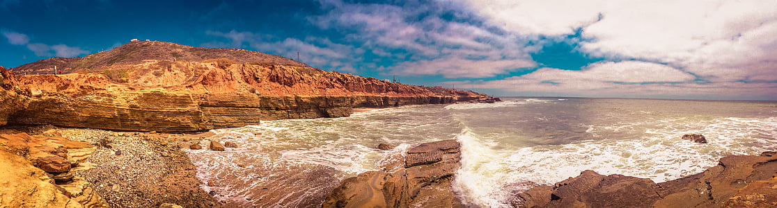 panorama photography of cliff beside body of water during daytime