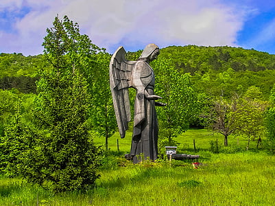 angel statue on plain grass field at daytime