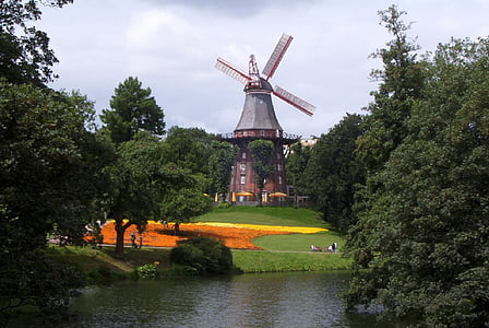 wind mill near trees and river