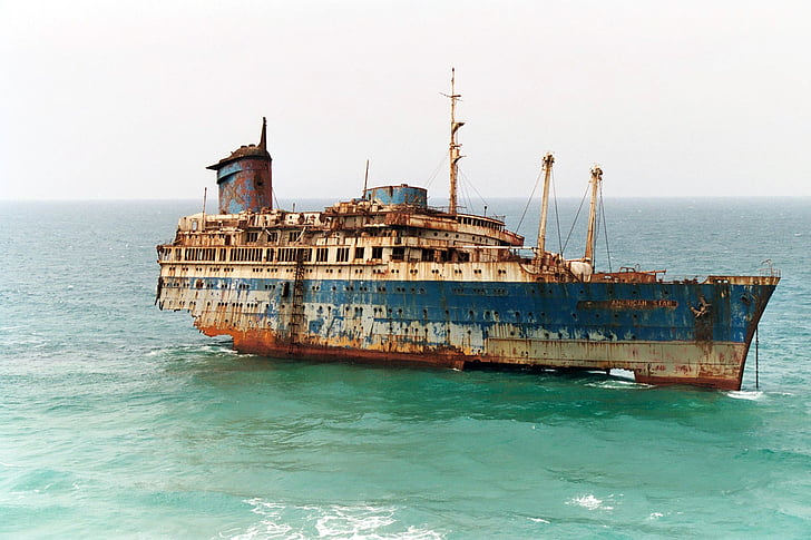 photo of blue and brown ship surrounded by body of water