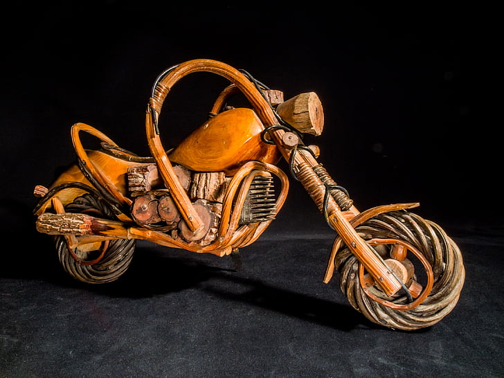 brown wooden miniature motorcycle with black background