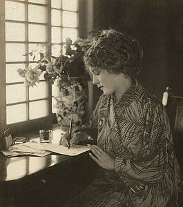 sepia photo of woman writing on paper