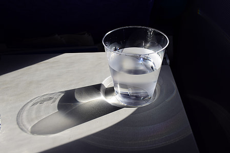 glass cup with water on white panel