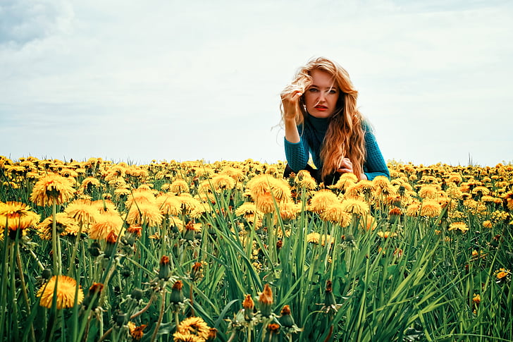 woman sitting on yellow dandelion field