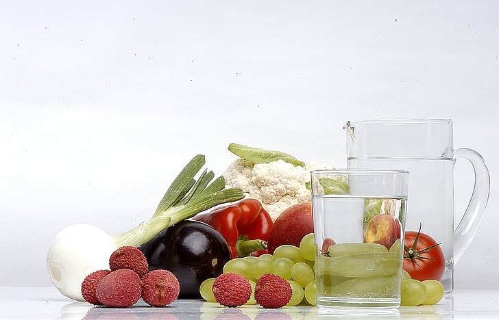 assorted fruit and vegetable beside clear glass pitcher