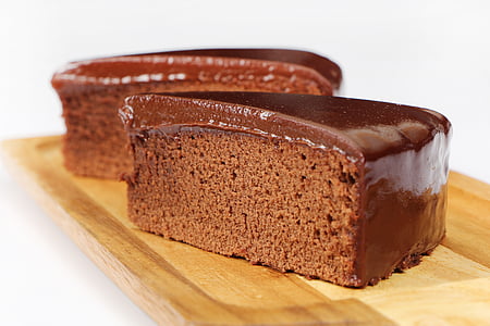 two slices of chocolate cakes on brown wooden board