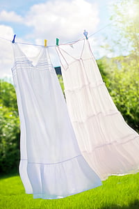 two white long dresses hanged on white rope