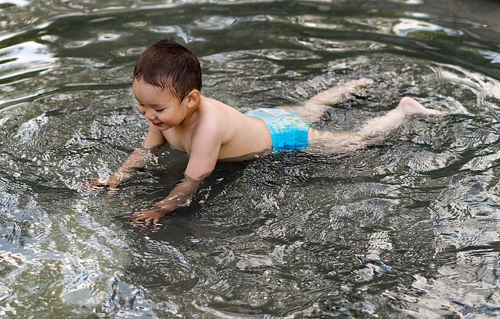 toddler playing on a body of water