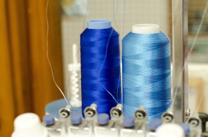 two blue and teal threads on interlocking machine
