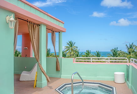 pink and teal building surrounded with coconut trees