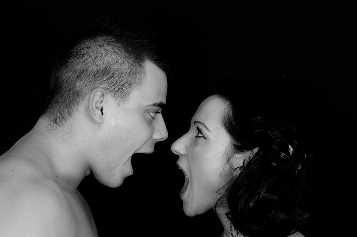 grayscale photo of man and woman facing each other