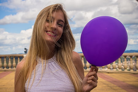 woman holding purple balloon