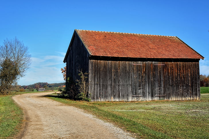 brown and black wooden barnhouse beside road
