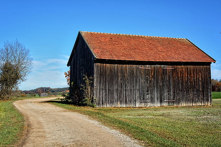 brown and black wooden barnhouse beside road