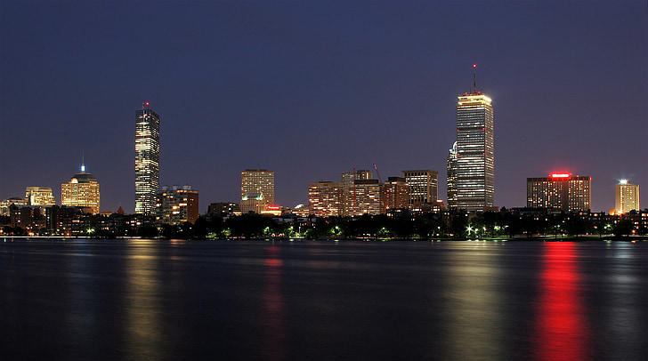 photo of high-rise buildings near body of water during night time