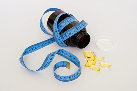 oval yellow medication capsules near bottle