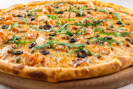 pizza with olives and green leaves