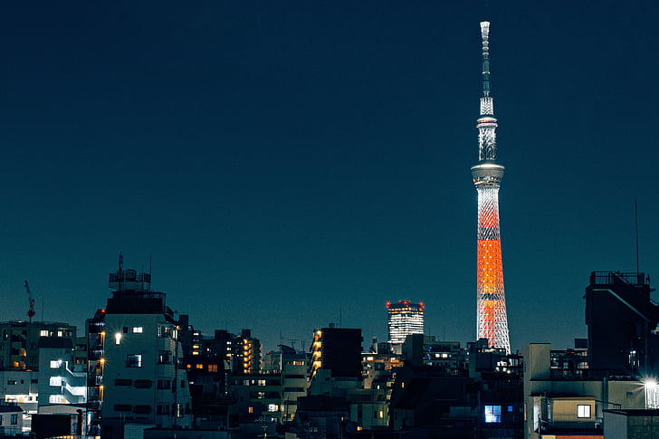 city skyline with orange and white tower at night