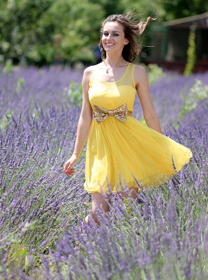 woman in dress standing on flower field
