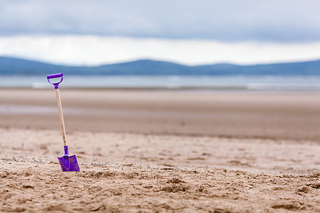 photo of purple shovel on sand